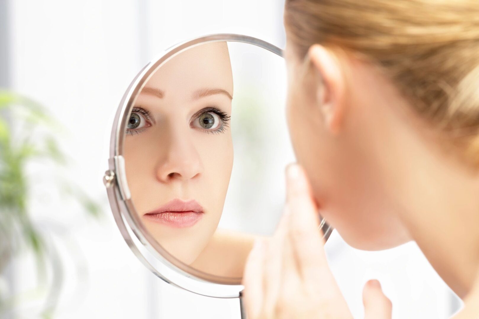 A woman examining her face in a mirror
