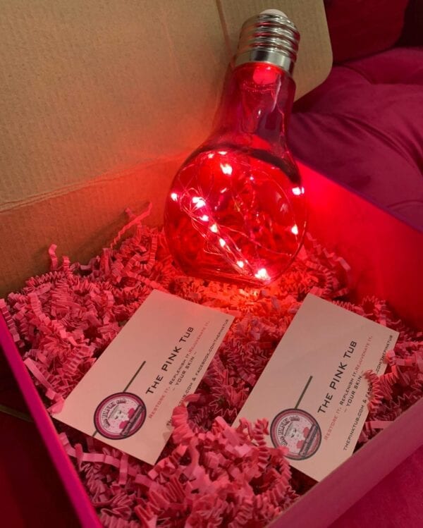 A pink box with some business cards and a light