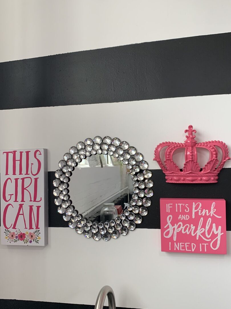 A mirror and some pink accessories on the wall