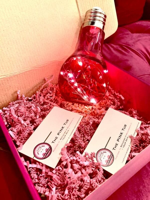 A red bottle and business cards in a box.